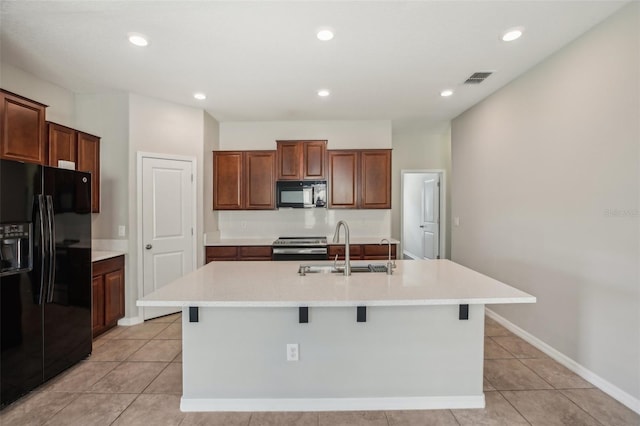 10326 Boggy Moss Dr, Riverview, FL 33578 - kitchen with black appliances, a sink, a kitchen island with sink, light countertops, and light tile patterned flooring