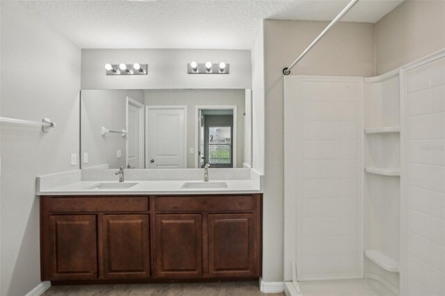 10326 Boggy Moss Dr, Riverview, FL 33578 - bathroom featuring a shower, double vanity, baseboards, and a textured ceiling