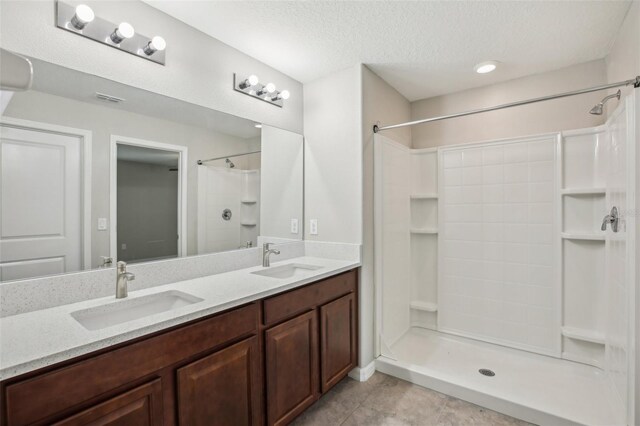 10326 Boggy Moss Dr, Riverview, FL 33578 - bathroom with double vanity, a shower, a textured ceiling, and tile patterned flooring