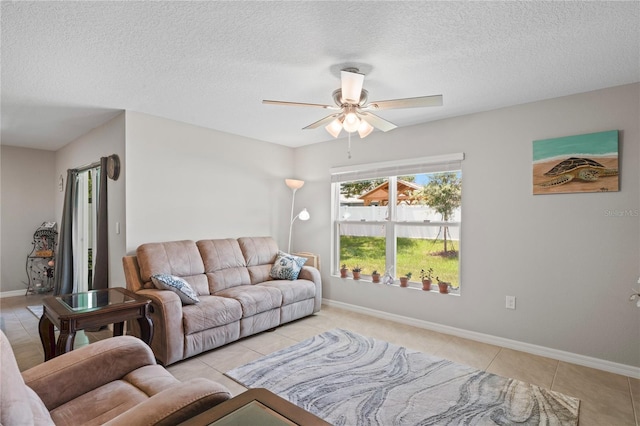 8508 Bay Dr, Spring Hill, FL 34606 - living room with light tile patterned floors, ceiling fan, a textured ceiling, and baseboards