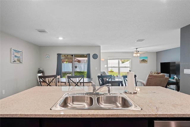 8508 Bay Dr, Spring Hill, FL 34606 - kitchen featuring a sink, open floor plan, dishwasher, ceiling fan, and a kitchen island with sink