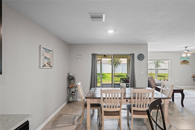 8508 Bay Dr, Spring Hill, FL 34606 - dining area featuring a textured ceiling, light tile patterned flooring, baseboards, and ceiling fan