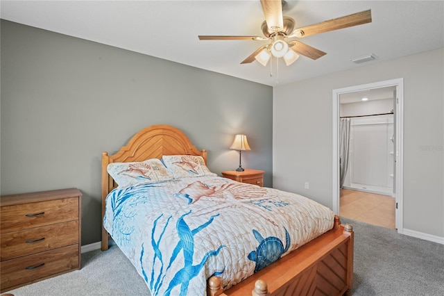 8508 Bay Dr, Spring Hill, FL 34606 - carpeted bedroom with baseboards, ensuite bath, and a ceiling fan