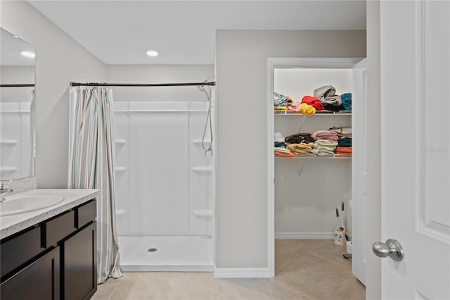 8508 Bay Dr, Spring Hill, FL 34606 - bathroom with tile patterned flooring, a stall shower, vanity, a walk in closet, and baseboards
