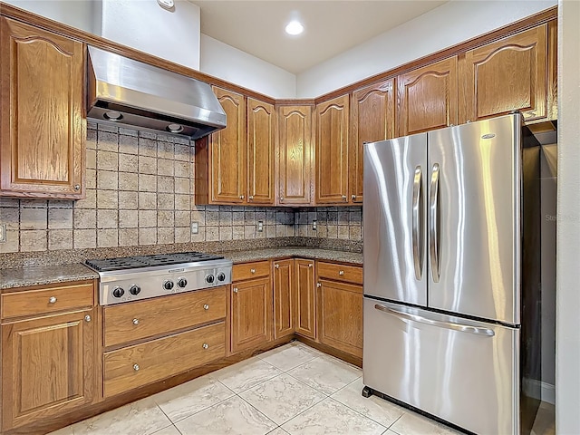 13110 Manistee Rd, Weeki Wachee, FL 34614 - kitchen featuring stainless steel appliances, under cabinet range hood, brown cabinetry, and tasteful backsplash