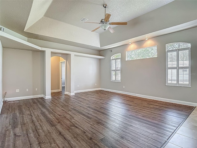 13110 Manistee Rd, Weeki Wachee, FL 34614 - empty room featuring arched walkways, a ceiling fan, wood finished floors, a textured ceiling, and baseboards