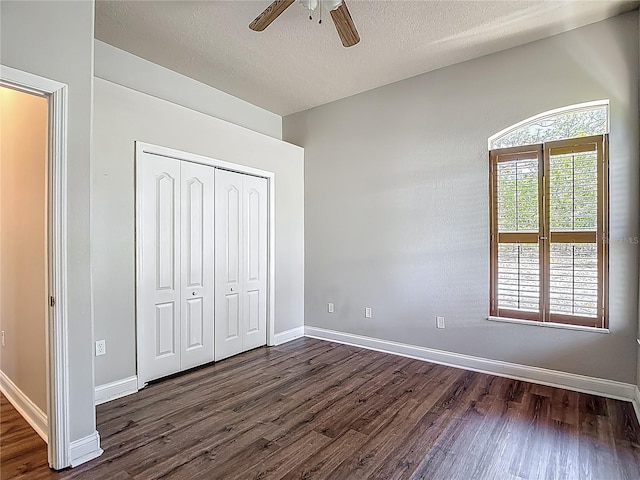 13110 Manistee Rd, Weeki Wachee, FL 34614 - unfurnished bedroom with dark wood-type flooring, a closet, baseboards, a textured ceiling, and ceiling fan