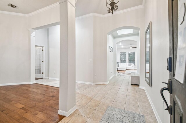 7410 Ambleside Dr, Land O Lakes, FL 34637 - foyer entrance with ornamental molding, arched walkways, light tile patterned floors, and baseboards