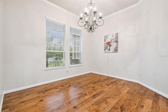 7410 Ambleside Dr, Land O Lakes, FL 34637 - empty room featuring a chandelier, crown molding, wood finished floors, and baseboards