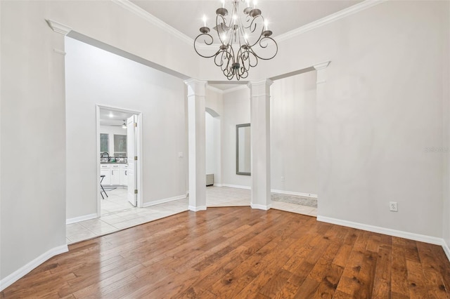 7410 Ambleside Dr, Land O Lakes, FL 34637 - unfurnished dining area with hardwood / wood-style flooring, ornate columns, crown molding, a chandelier, and baseboards