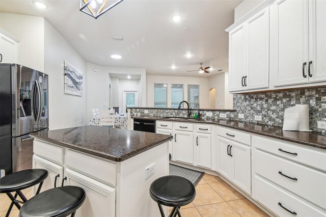 7410 Ambleside Dr, Land O Lakes, FL 34637 - kitchen featuring stainless steel fridge, a sink, ceiling fan, a kitchen breakfast bar, and black dishwasher