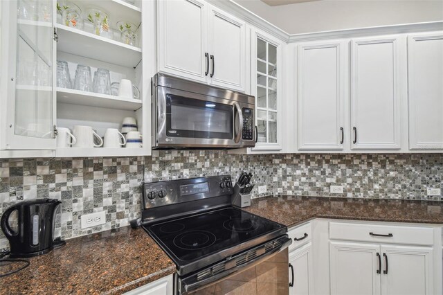 7410 Ambleside Dr, Land O Lakes, FL 34637 - kitchen with stainless steel microwave, black range with electric stovetop, white cabinets, and glass insert cabinets