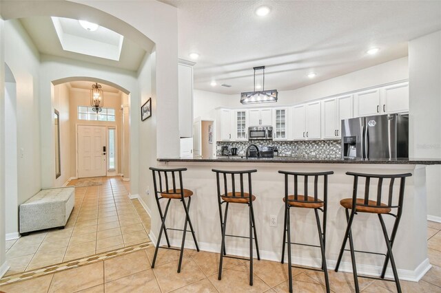 7410 Ambleside Dr, Land O Lakes, FL 34637 - kitchen featuring appliances with stainless steel finishes, a kitchen breakfast bar, white cabinets, and recessed lighting