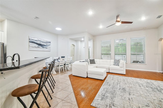 7410 Ambleside Dr, Land O Lakes, FL 34637 - living room featuring arched walkways, a ceiling fan, recessed lighting, light tile patterned floors, and baseboards