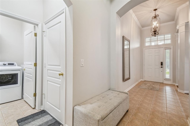 7410 Ambleside Dr, Land O Lakes, FL 34637 - foyer with washer / dryer, light tile patterned floors, arched walkways, a chandelier, and ornamental molding