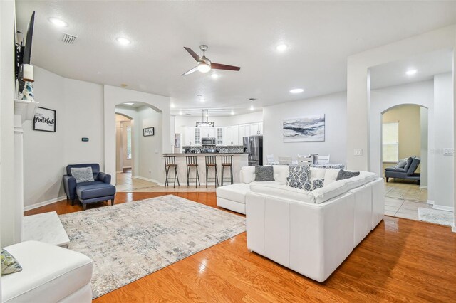 7410 Ambleside Dr, Land O Lakes, FL 34637 - living area featuring arched walkways, ceiling fan, light wood finished floors, and recessed lighting