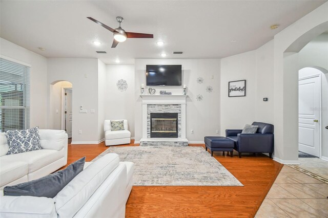 7410 Ambleside Dr, Land O Lakes, FL 34637 - living room with arched walkways, ceiling fan, a glass covered fireplace, baseboards, and recessed lighting
