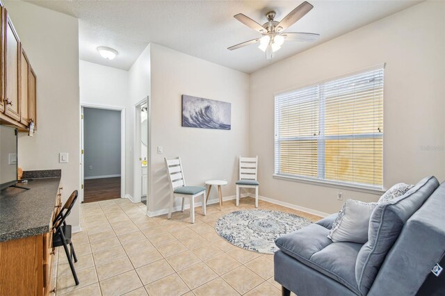 7410 Ambleside Dr, Land O Lakes, FL 34637 - living area featuring a ceiling fan, light tile patterned floors, and baseboards