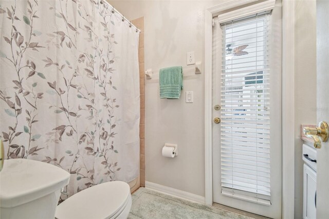 7410 Ambleside Dr, Land O Lakes, FL 34637 - full bathroom featuring toilet, baseboards, and a shower with shower curtain