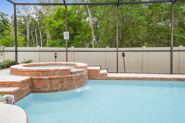 7410 Ambleside Dr, Land O Lakes, FL 34637 - view of swimming pool featuring a fenced backyard, a pool with connected hot tub, and view of scattered trees