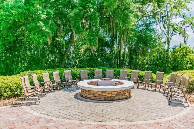7410 Ambleside Dr, Land O Lakes, FL 34637 - view of patio featuring an outdoor fire pit and view of wooded area