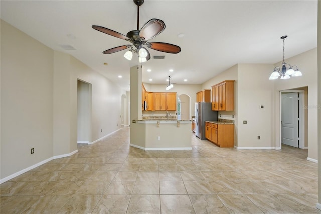 5340 Riva Ridge Dr, Wesley Chapel, FL 33544 - kitchen featuring freestanding refrigerator, arched walkways, ceiling fan, open floor plan, and a peninsula