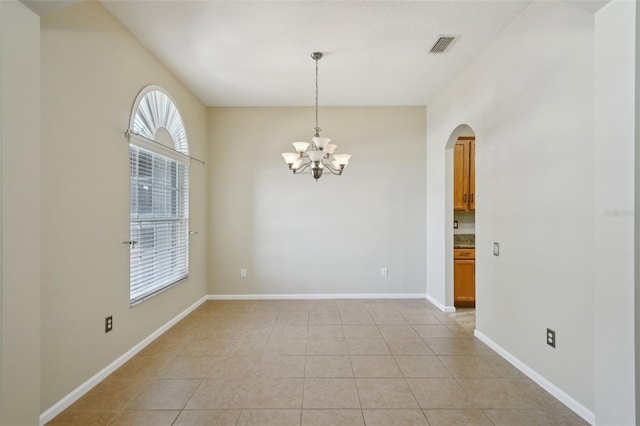 5340 Riva Ridge Dr, Wesley Chapel, FL 33544 - unfurnished room featuring arched walkways, light tile patterned flooring, a chandelier, and baseboards