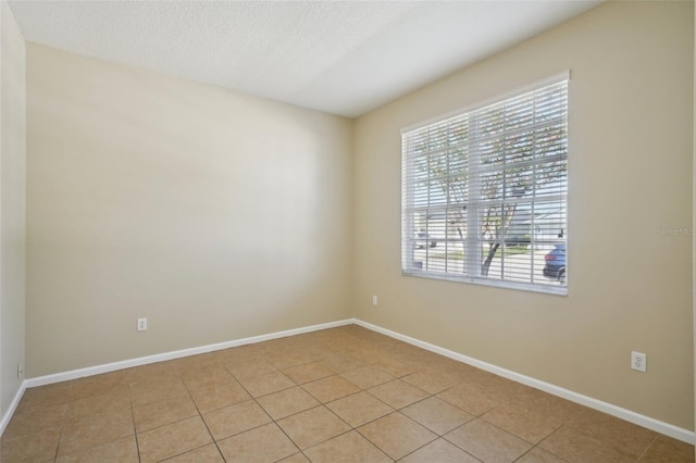 5340 Riva Ridge Dr, Wesley Chapel, FL 33544 - empty room with a textured ceiling, light tile patterned floors, and baseboards