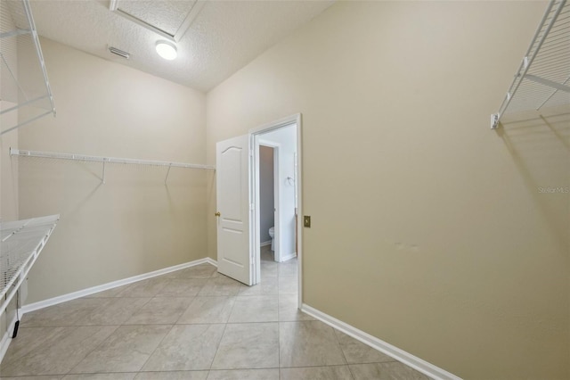 5340 Riva Ridge Dr, Wesley Chapel, FL 33544 - spacious closet featuring light tile patterned floors, vaulted ceiling, and attic access