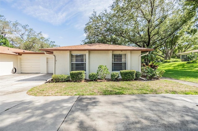 2150 Shelly Dr Unit D, Palm Harbor, FL 34684 - view of front of house featuring stucco siding, a garage, a front lawn, and driveway