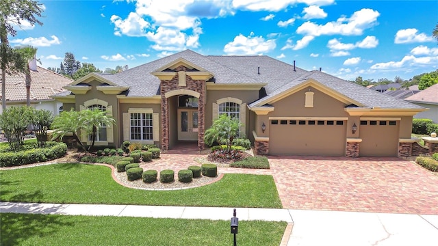 3123 Whitehead Ln, Land O Lakes, FL 34638 - view of front of house with stucco siding, a garage, decorative driveway, and a front lawn