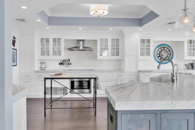 555 5th Ave NE Unit 1032, Saint Petersburg, FL 33701 - kitchen with wall chimney exhaust hood, wine cooler, a tray ceiling, crown molding, and white cabinetry