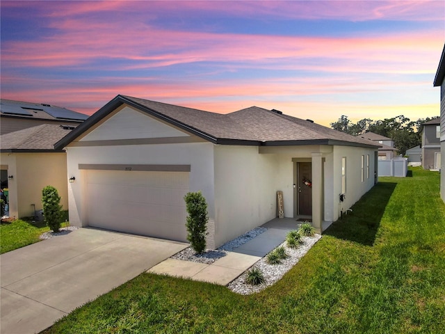 35552 Shade Fern Ln, Zephyrhills, FL 33541 - ranch-style house with an attached garage, a yard, stucco siding, a shingled roof, and driveway