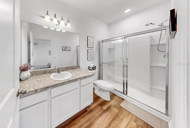 35552 Shade Fern Ln, Zephyrhills, FL 33541 - full bathroom with a shower stall, vanity, wood finished floors, and toilet