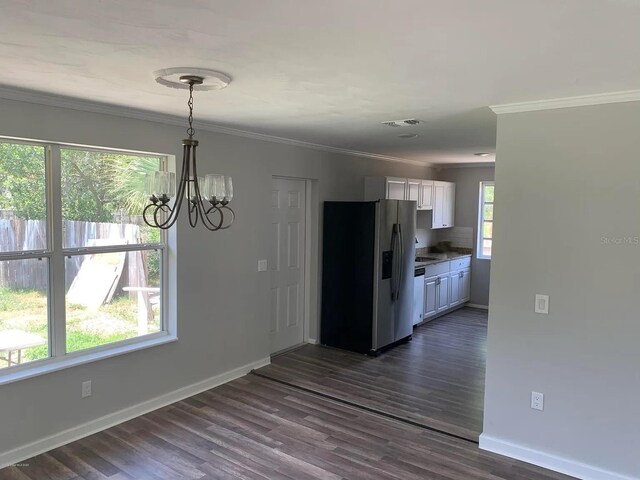 808 Hillsdale Dr, Cocoa, FL 32922 - kitchen with stainless steel refrigerator with ice dispenser, a chandelier, white cabinets, baseboards, and crown molding