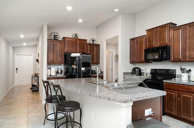 17334 White Mangrove Dr, Wimauma, FL 33598 - kitchen featuring black appliances, a kitchen island with sink, lofted ceiling, a sink, and a breakfast bar