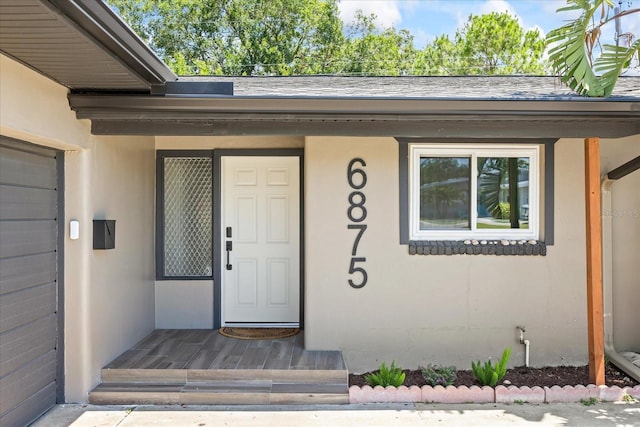 6875 11th Ave N, Saint Petersburg, FL 33710 - entrance to property with a garage, stucco siding, and a shingled roof