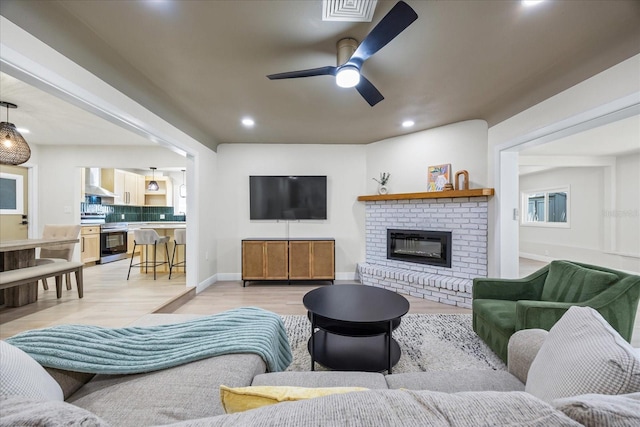 6875 11th Ave N, Saint Petersburg, FL 33710 - living area featuring a ceiling fan, light wood finished floors, recessed lighting, baseboards, and a fireplace