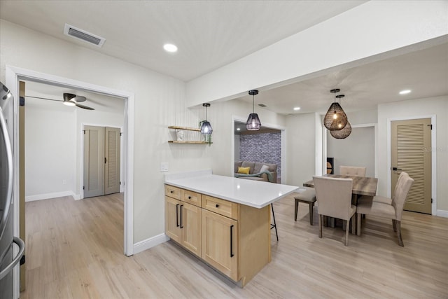 6875 11th Ave N, Saint Petersburg, FL 33710 - kitchen featuring light brown cabinetry, light wood-style floors, light countertops, pendant lighting, and recessed lighting