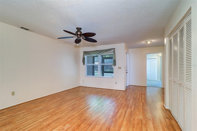 3053 Gregor Ct, Palm Harbor, FL 34684 - spare room featuring light wood finished floors, a textured ceiling, a ceiling fan, and baseboards