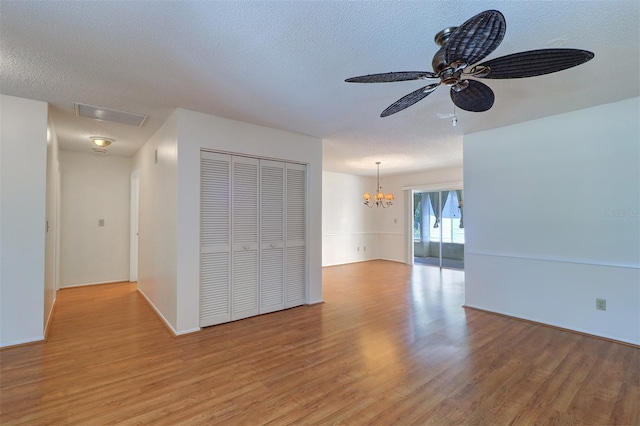 3053 Gregor Ct, Palm Harbor, FL 34684 - unfurnished room with light wood finished floors, a chandelier, ceiling fan, a textured ceiling, and baseboards