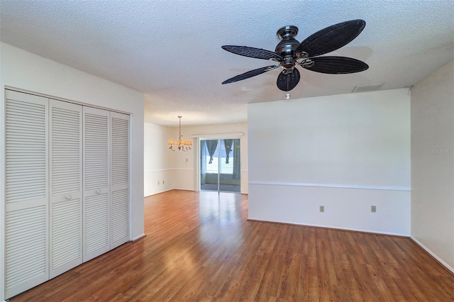 3053 Gregor Ct, Palm Harbor, FL 34684 - unfurnished living room with wood finished floors, a chandelier, a textured ceiling, ceiling fan, and baseboards