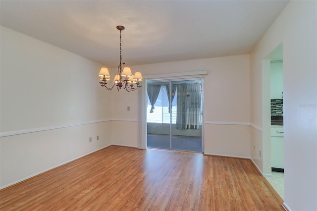 3053 Gregor Ct, Palm Harbor, FL 34684 - unfurnished room featuring light wood-style flooring, a chandelier, and baseboards