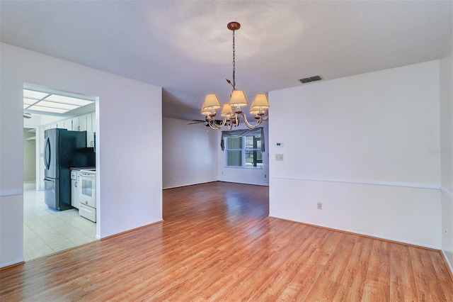 3053 Gregor Ct, Palm Harbor, FL 34684 - unfurnished room featuring a chandelier and light wood-style floors