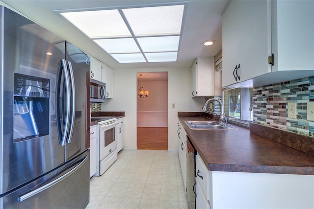 3053 Gregor Ct, Palm Harbor, FL 34684 - kitchen with appliances with stainless steel finishes, a sink, dark countertops, a chandelier, and tasteful backsplash
