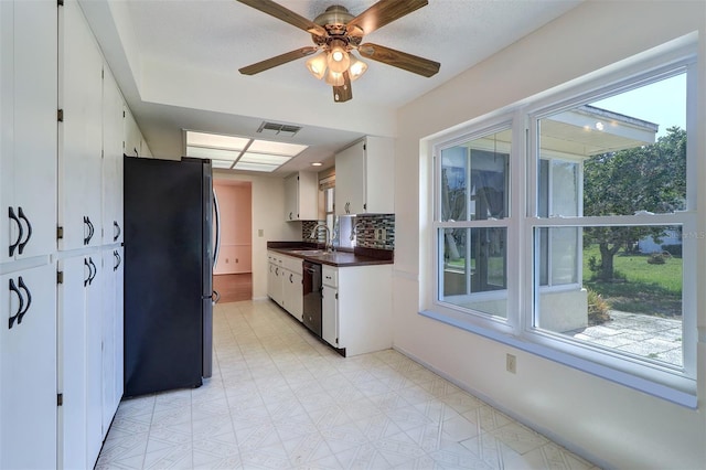 3053 Gregor Ct, Palm Harbor, FL 34684 - kitchen with freestanding refrigerator, dark countertops, dishwasher, white cabinetry, and a sink