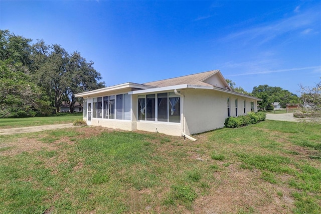 3053 Gregor Ct, Palm Harbor, FL 34684 - view of home's exterior with stucco siding, a yard, and a sunroom