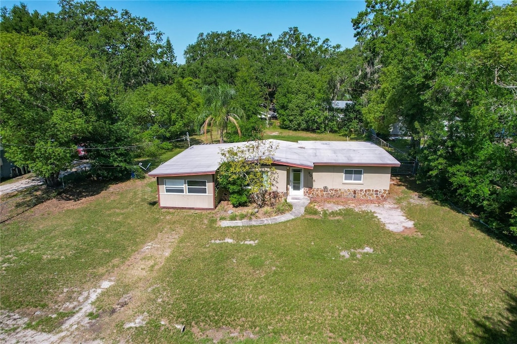 2015 Pleasant Acre Dr, Plant City, FL 33566 - view of front facade featuring a front lawn, dirt driveway, and a wooded view