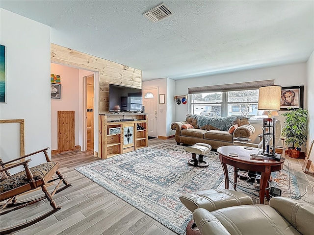 602 Mindy Dr, Largo, FL 33771 - living area featuring light wood-type flooring, a textured ceiling, and baseboards