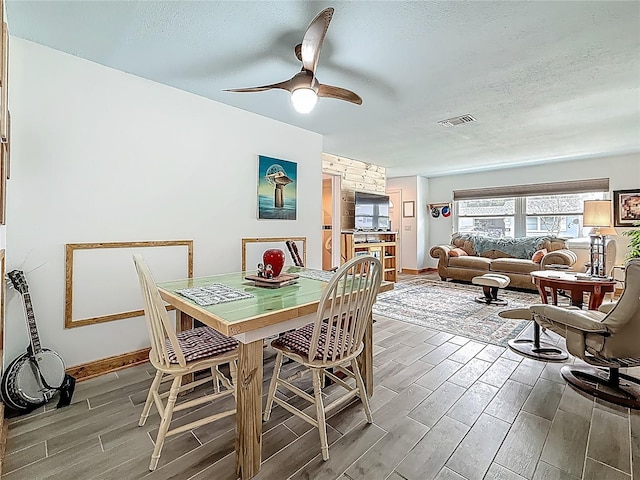 602 Mindy Dr, Largo, FL 33771 - dining room featuring a textured ceiling, wood tiled floors, a ceiling fan, and baseboards